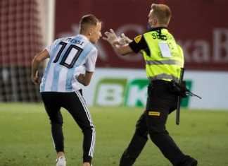 Seorang penggemar Lionel Messi (kiri) merangsek masuk ke lapangan Estadi de Son Moix di Palma de Mallorca