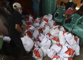 Petugas menata paket sembako dan makanan siap saji di Kelurahan Kebon Baru, Tebet, Jakarta Selatan, Rabu (8/4). [Suara.com/Angga Budhiyanto]
