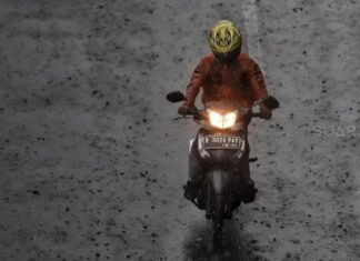 Pengendara meliintasi hujan di kawasan Gatot Subroto, Jakarta, Senin (11/2). [Suara.com/Muhaimin A Untung]