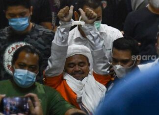 Habib Rizieq Shihab menggunakan baju tahanan usai diperiksa penyidik Polda Metro Jaya, Minggu (13/12/2020) dini hari. [Suara.com/Alfian Winanto]
