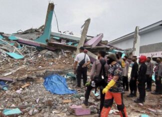 Petugas mengamati bangunan RS Mitra Manakarra yang roboh pascagempa bumi, di Mamuju, Sulawesi Barat, Jumat (15/1/2021). [ANTARA FOTO/Akbar Tado]