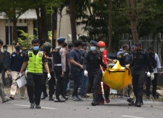 Petugas kepolisian mengangkat kantong jenazah berisi bagian tubuh dari terduga pelaku bom bunuh diri di depan Gereja Katedral Makassar, Sulawesi Selatan, Minggu (28/3/2021). ANTARA FOTO/Indra Abriyanto