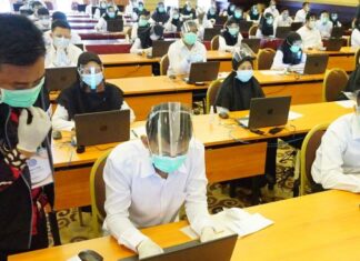Petugas memandu peserta melakukan proses login komputer ujian Seleksi Kemampuan Bidang (SKB) di program penjaringan CPNS 2019 di Tulungagung, Jawa Timur, Rabu (30/9/2020). [ANTARA FOTO/Destyan Sujarwoko]
