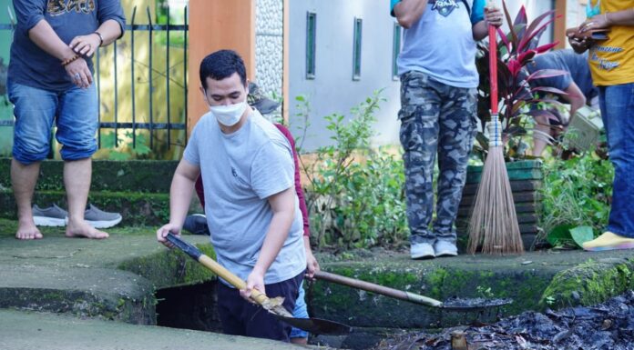 Bupati Kabupaten Pangkep Muhammad Yusran Lalogau, membersihkan selokan dari sampah plastik.(Pangkep.terkini.id).
