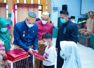 Bupati Pangkep Muhammad Yusran Lalogau (tegah) memberikan bingkisan kepada siswa di Hari Pendidikan Nasional 2021.(Ist).