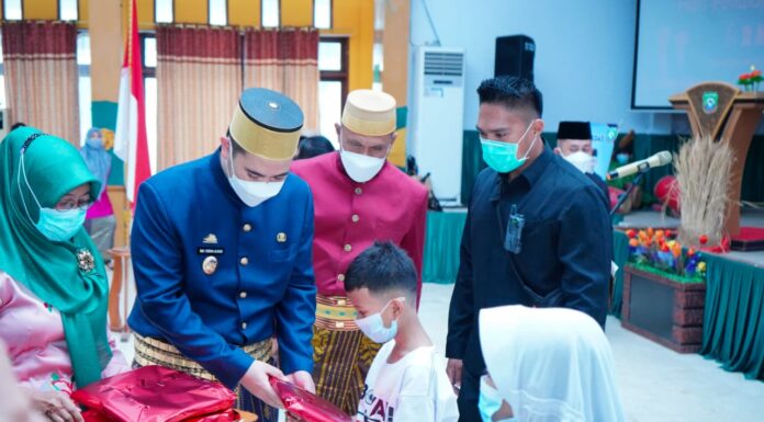 Bupati Pangkep Muhammad Yusran Lalogau (tegah) memberikan bingkisan kepada siswa di Hari Pendidikan Nasional 2021.(Ist).