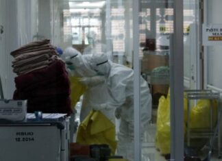 Petugas kesehatan memakai APD mengumpulkan limbah medis di ruang perawatan pasien COVID-19 di RSUD Kota Bogor, Jawa Barat, Rabu (16/6/2021). [Antara/Arif Firmansyah]